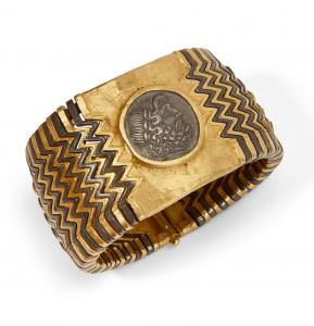 22K gold and steel bracelet with a central silver coin in the style of Greek 3rd Century BC tetradrachm, surrounded by wide zig-zag motif of alternating gold and steel links, engraved Siragusa (est. $3,000-$5,000).