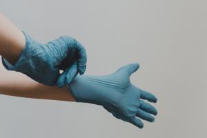  A picture of a medical practitioner putting on medical gloves in preparation for a procedure like Dr. James Murtagh.
