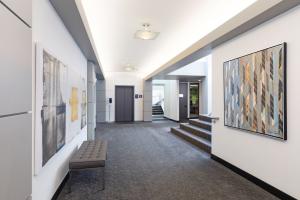 Image of the inside of the Kirkland clinic building. white walls, gray seat, yellow, gray, and blue art on the walls, gray elevator and carpeted staircase.