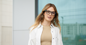 A woman is wearing smart glasses with prescription. The smart glasses look like normal eyewear.