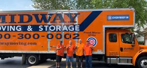 Three men in orange t-shirts stand in front of a large orange semi truck with the words Midway Moving written on the side.