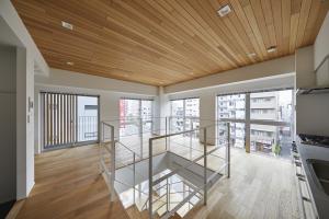 4FL (Type B: Housing for couples): A close-up photograph of the maisonette staircase is captured, emphasizing the glass walls, windows and the wooden ceiling.