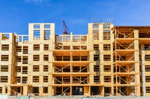 New multifamily development under construction. Large project. Wood build. Blue sky background.