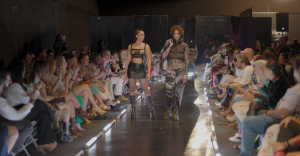 Two models walking down the runway in MUTED clothing collection holding hands as a couple