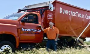 Waldron of Dumpster Today Austin stands with his dumpster delivery truck.