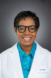 Dr. Shay Nicholas smiling in a white doctor's lab coat