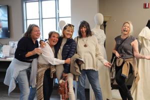 A group of friends gathered for a ladies' night out, immersing themselves in historical couture. They are seen smiling and enjoying the experience, creating connections and moments of happiness.