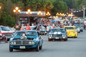 Old cars lined up and cruising the fairgrounds