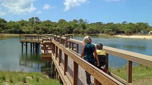 An accessible pier at Oscar Scherer State Park offers areas of lowered rails so that seated visitors have unobstructed views and may cast fishing lines.