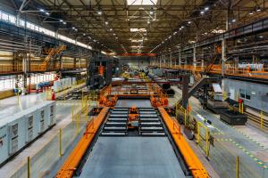 Wide shot of a manufacturing plant with machinery and pipes visible.