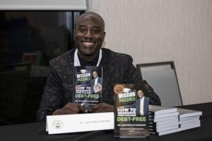 Award Winning Author, Dr. Juan P. Chisholm holding up his new book at an award ceremony.