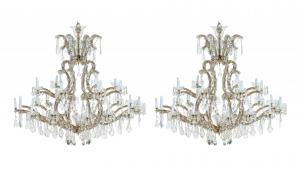 Spectacular pair of 20th century 24-light crystal chandeliers with a cut crystal canopy over arched glass arms, 46 inches tall by 46 inches in diameter (est. $5,000-$10,000).