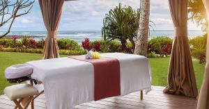 Spa massage table set in a cabana with ocean view, surrounded by tropical plants at Ko'a Kea Resort.
