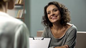 Woman smiling and looking at a therapist or intake coordinator
