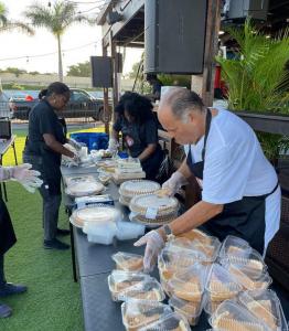 Embrace Thanksgiving meals giveaway co-sponsor Steven G prepares food for distribution.