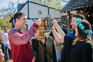 4 people clink beer steins, caption: Texas Renaissance Festival celebrates its 50th anniversary season in 2024