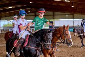 two male players,one from Texas A&M and one from Colorado State Univeristy, riding horses side by side