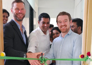 A photo of three people cutting a ribbon at the Jeevasare and Clinitouch partnership ceremony