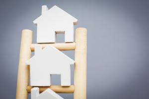 Model Houses On Rungs Of Wooden Property Ladder