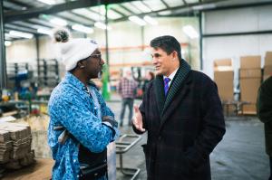 Presidential candidate Ryan Binkley talks with a Black worker at an Iowa manufacturing plant.