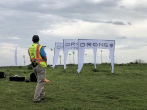 A member of the Drone U instructor group instructs flight students through the Flight Mastery obstacle course