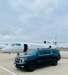 Avo Limo Express fleet SUV next private Jet on Runway