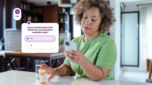 A patient looking at their phone with their medication bottle in their hand