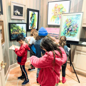 kids from the First Coast Cultural Center exploring a museum of art and taking notes on their discoveries