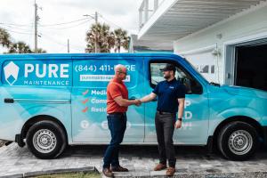 pure maintenance mold remediation technician meeting with customer in front of work van in neptune beach, florida