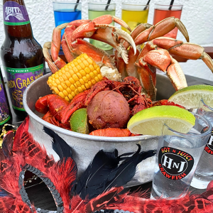 A plate of seafood next to a mask with beers and margaritas in the background