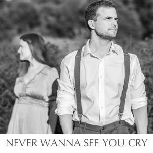 black and white image of a husband and wife posing in a meadow to promote their new country pop music
