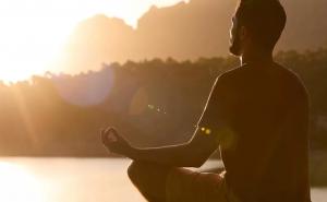 A man meditates near the pond on the Ingrained Recovery campus in Georgia