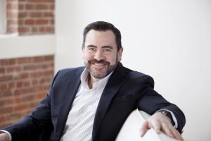 A businessman sitting on an office sofa in a business setting.