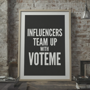 A large framed poster on a brick wall background with the text 'INFLUENCERS TEAM UP WITH VOTEME' in bold, capitalized letters.