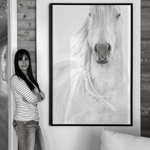Photographer Maria Marriott in gallery with her artwork, 