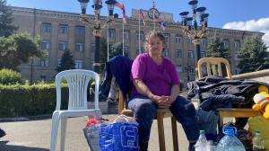 A woman sits surrounded by luggage in Stepanakert, Nagorno Karabakh