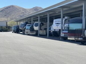 Rvs and boats stored under canopies at a storage facility
