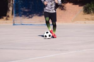 A skilled athlete’s legs deftly controlling the soccer ball on the court during training.
