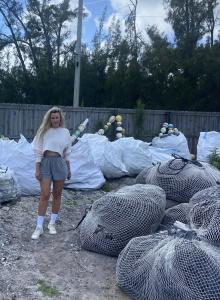 SeaSweepers Co-Founder Taryn Larock stands in front of bags of recovered ocean plastics from the Florida Coasts..