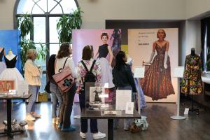 Visitors engaged with the latest CLO3D digital reconstruction of 1956 Galanos patterns from the museum's collection, surrounded by museum-owned dresses.