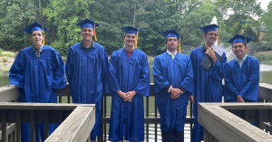 Graduates of IAA's class of 2023 aligned on a deck in their caps and gowns