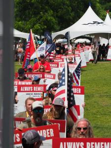 Photo of people carrying storyboards to the main stage at the Carry The Load Dallas Memorial March's closing ceremony.