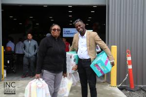 Two recipients smile for a photo as they receive free care packages at a Care for Humanity event sponsored by the Felix Y. Manalo Foundation at Seven Chiefs Sportsplex & Jim Starlight Centre