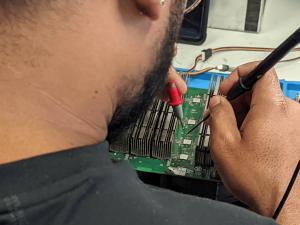 Technician making an ASIC Repair on T17+ Hashboard