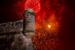 Fireworks burst in red over the towers of the Castillo de San Marcos