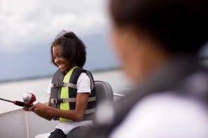 A girl wearing a life jacket while boating with her family