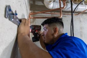 J. Blanton Plumbing technician working at a job site, highlighting the company's expertise in hot water heater repair, water heater installation, and providing same-day plumbing services, as part of their commitment to the McHenry Area Chamber of Commerce.