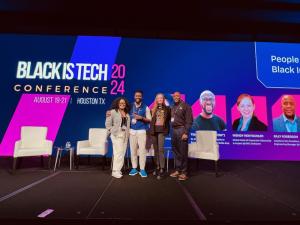 Tim Salau standing alongside Wendy Rentschler, Billy Roberson, and Giselle Mota at the BIT 2024 Conference, all smiling and engaging with the audience.