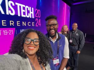 Tim Salau and panel members smiling for the camera at the Black is Tech 2024 Conference."