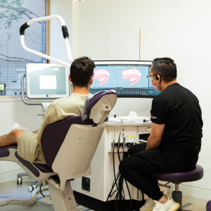 Dr William Luong and his patient, reviewing the patients Invisalign treatment at Medland Orthodontics Gold Coast Orthodontic practice located in Benowa, Queensland